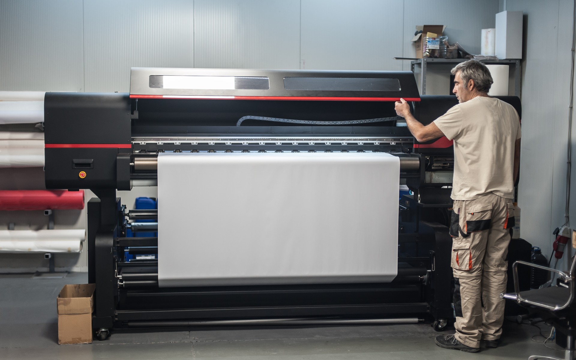 Technician operator works on large premium industrial printer plotter machine